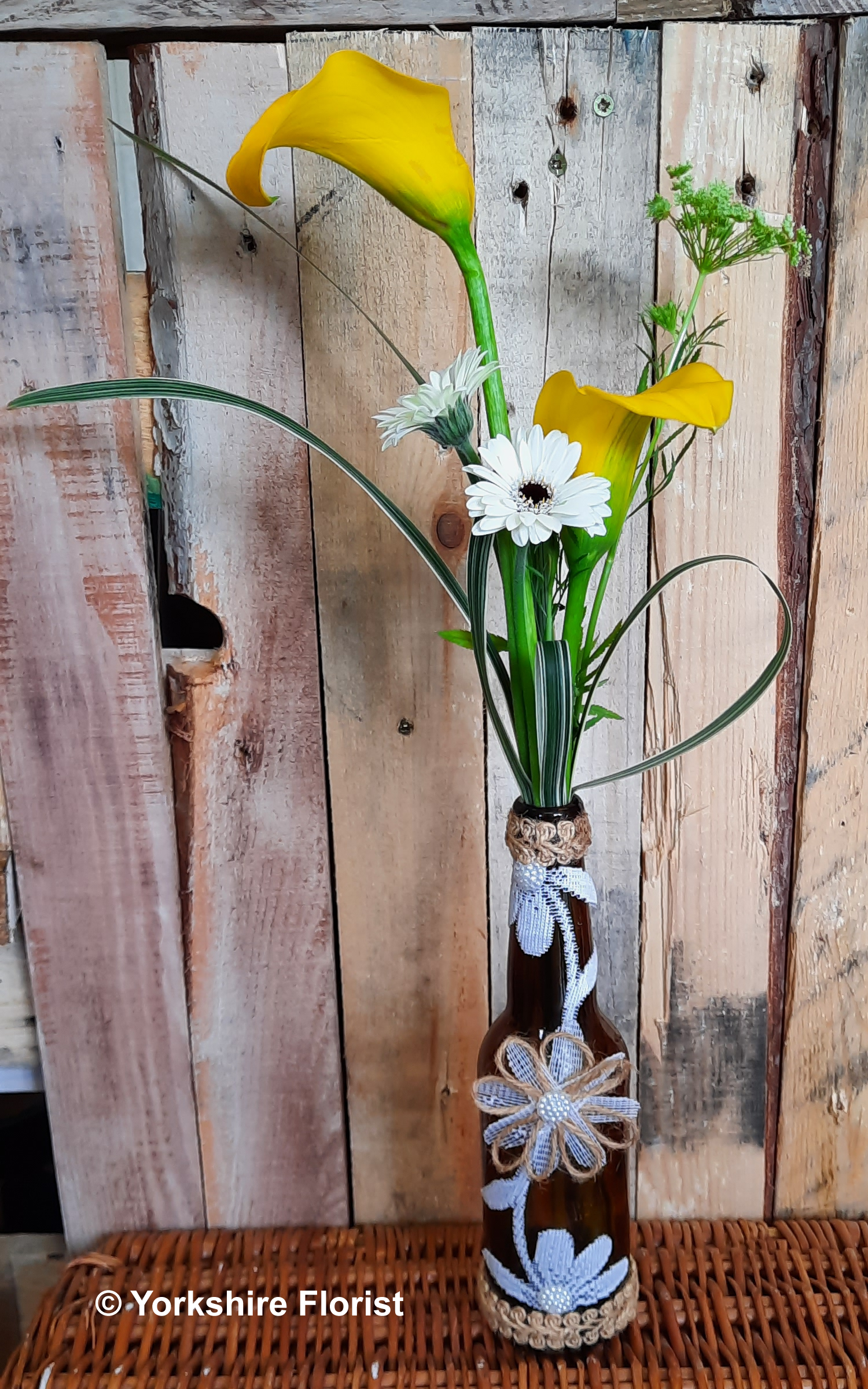 fresh flowers in decorated bottle