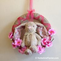 Jute wreath with bunny sitting in cherry blossoms and willow